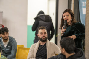 Een vrouw met een microfoon vraagt iets aan een man met een baard